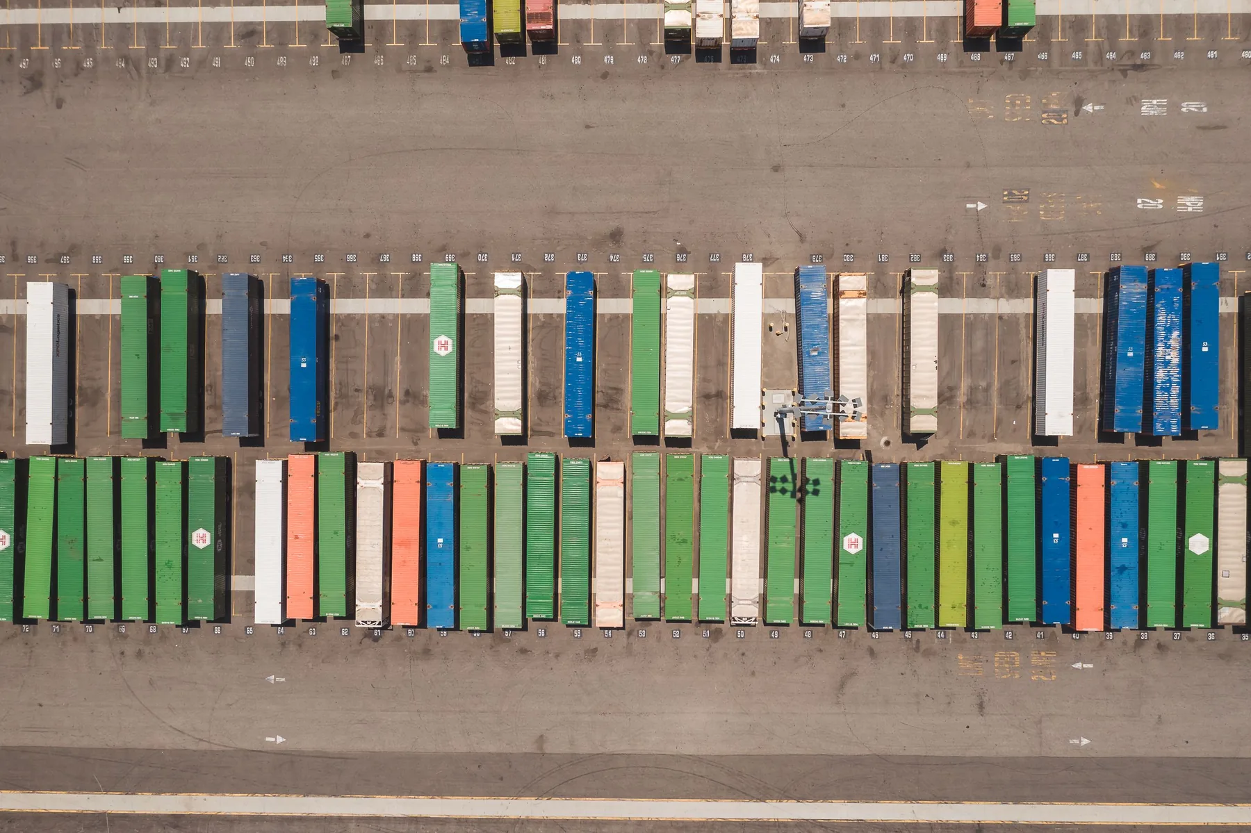 Aerial view of organised shipping containers in a logistics yard