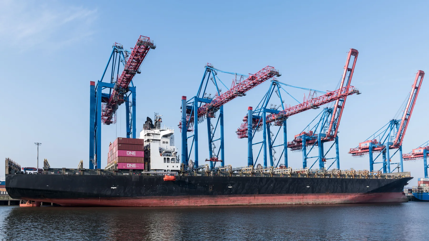 Large container ship positioned beside terminal cranes