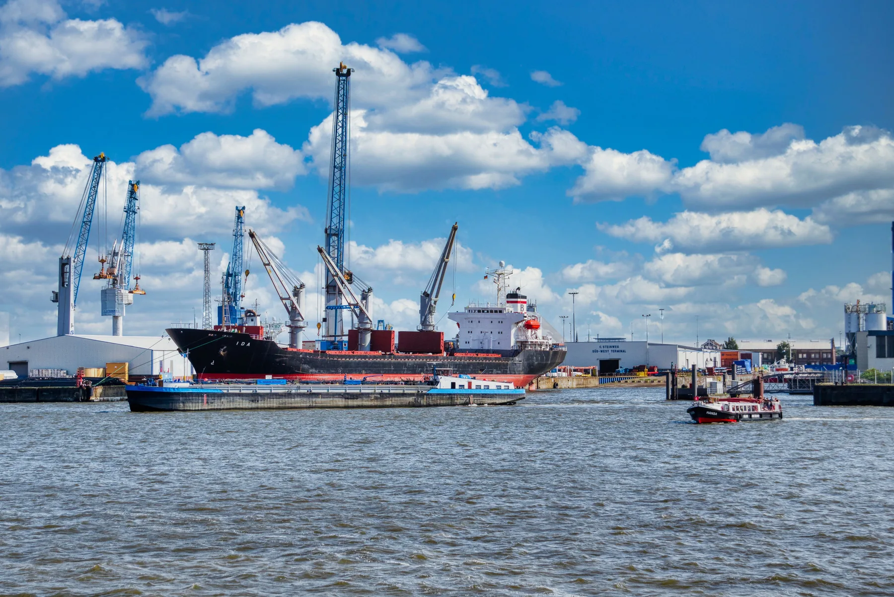 Cargo vessel and port cranes at a waterfront terminal