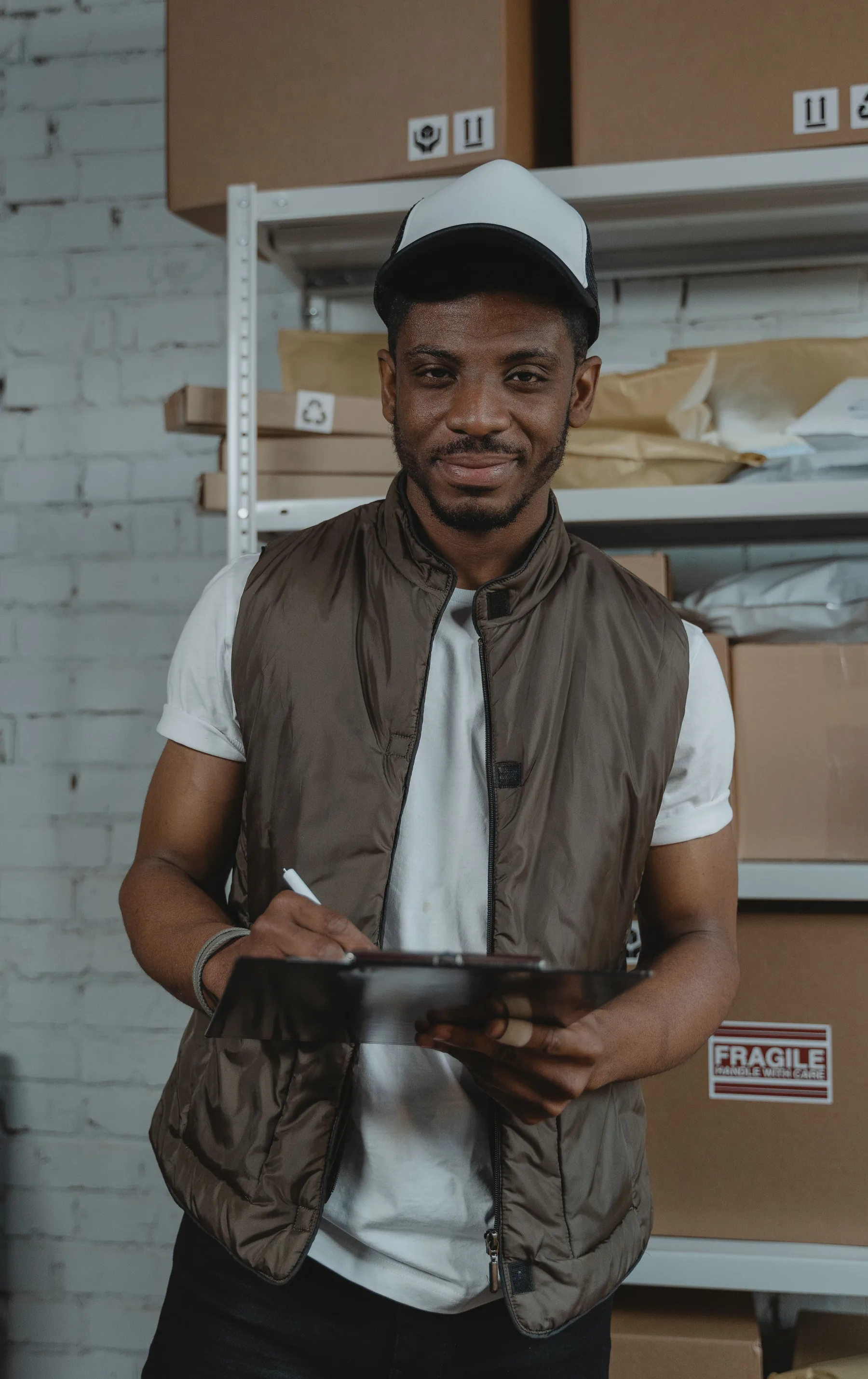 Logistics coordinator holding a clipboard in a parcel storage area