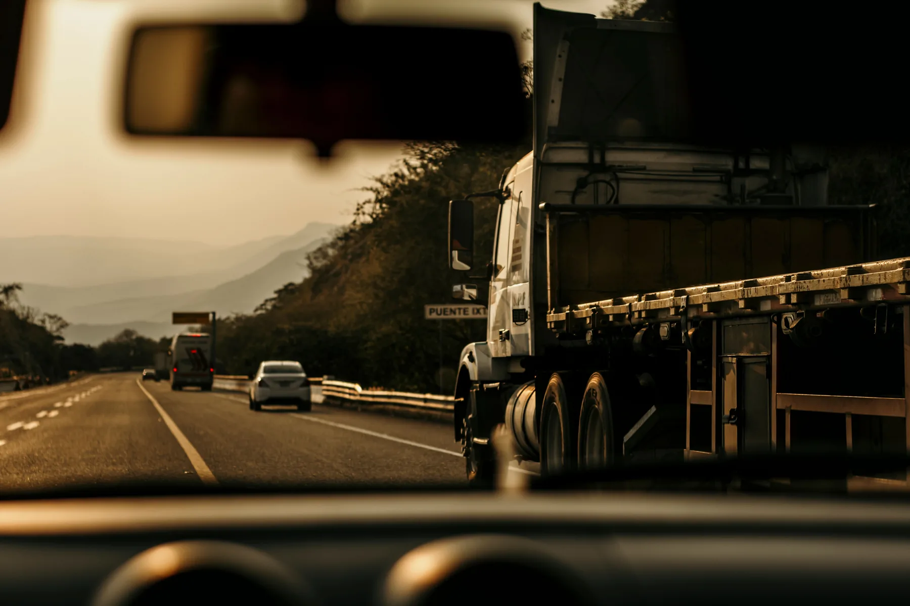 Commercial truck travelling on a highway at sunset