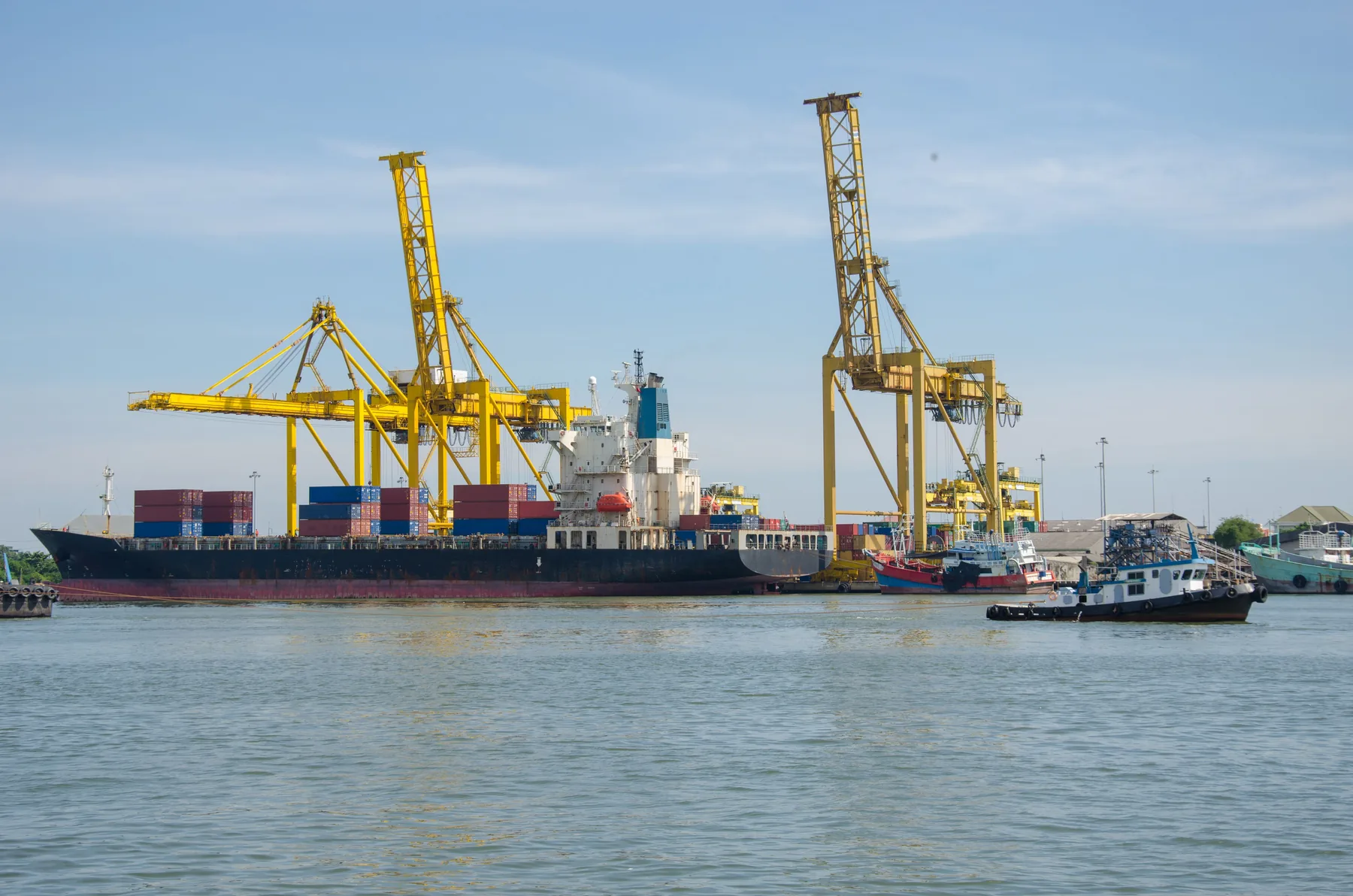 Cargo vessel beside yellow port cranes
